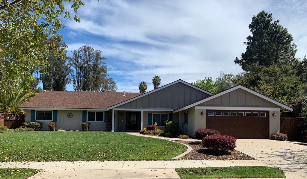A house with a grey roof and a brown garage door.