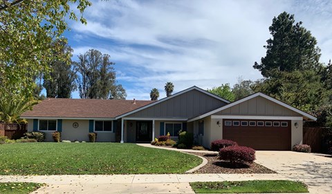 A house with a grey roof and a brown garage door.
