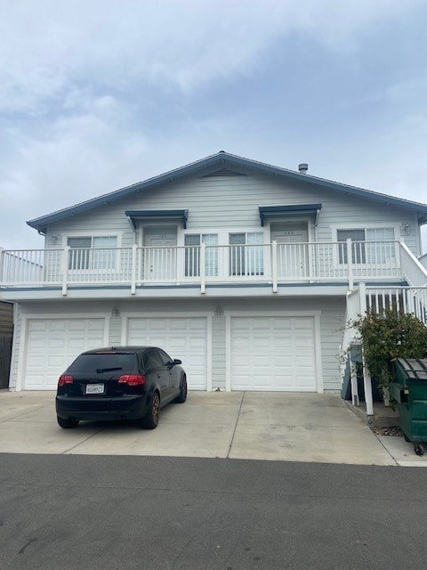 A car is parked in front of a two-story house.