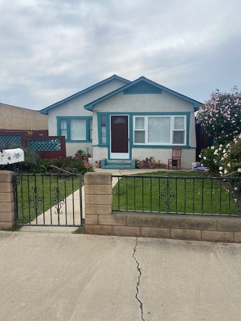 A blue house with a white fence and a gate.