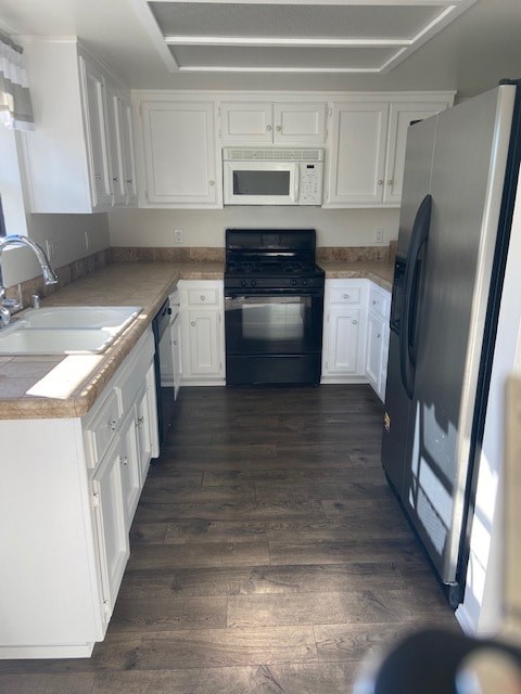 A kitchen with white cabinets and a black oven.