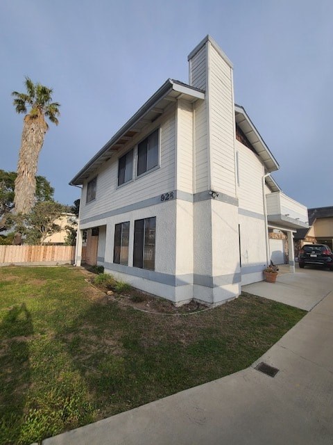 A house with a white exterior and a brown roof is shown.
