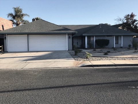 A house with a grey roof and a white garage door.