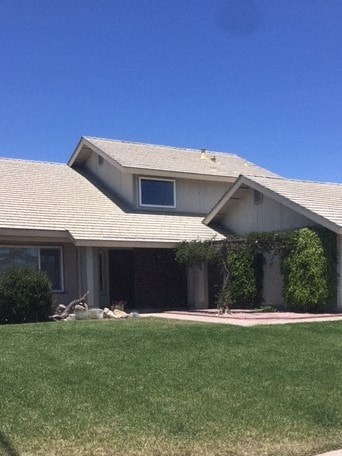A house with a grey roof and a small window on the side.