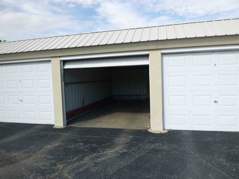 A large garage door is open, revealing a spacious interior.