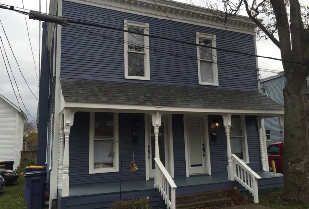 a house with blue siding and a white porch