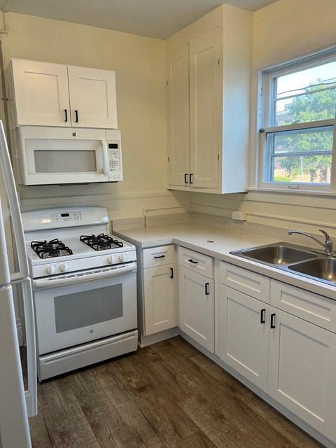 a kitchen with white cabinets and a stove and a sink