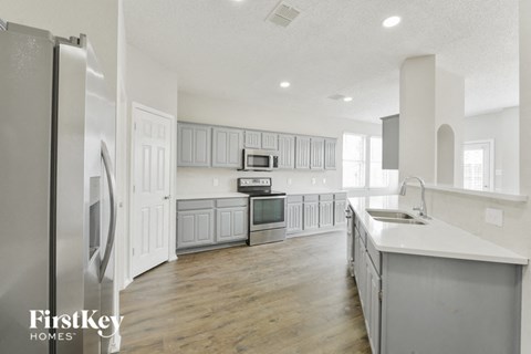a large kitchen with white cabinets and stainless steel appliances