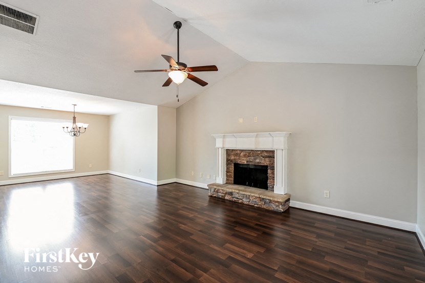 a living room with a fireplace and a ceiling fan