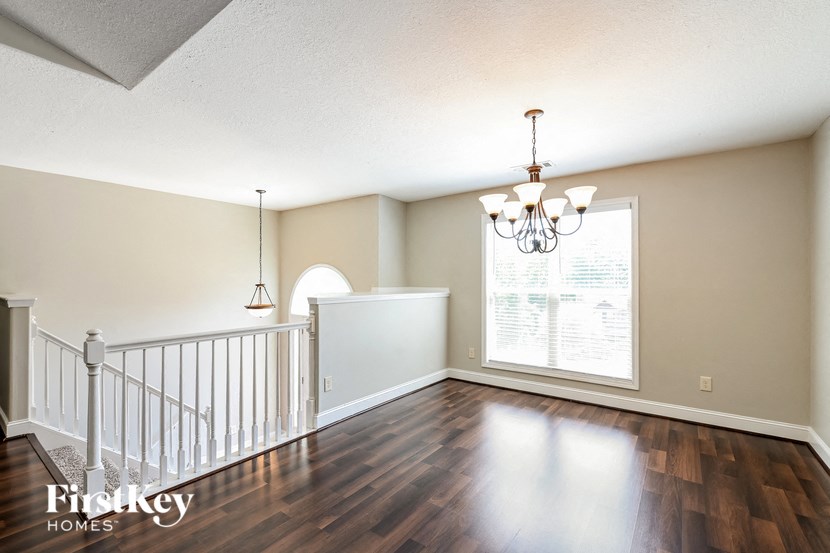 an empty living room with a staircase and a large window