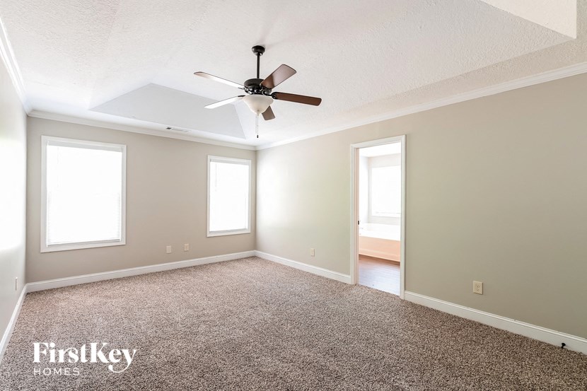 an empty living room with a ceiling fan
