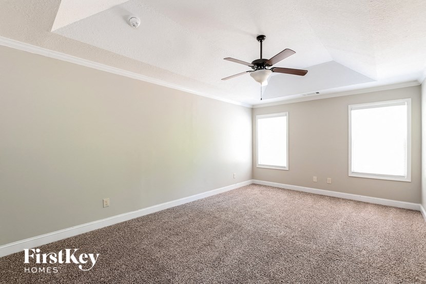 an empty living room with a ceiling fan