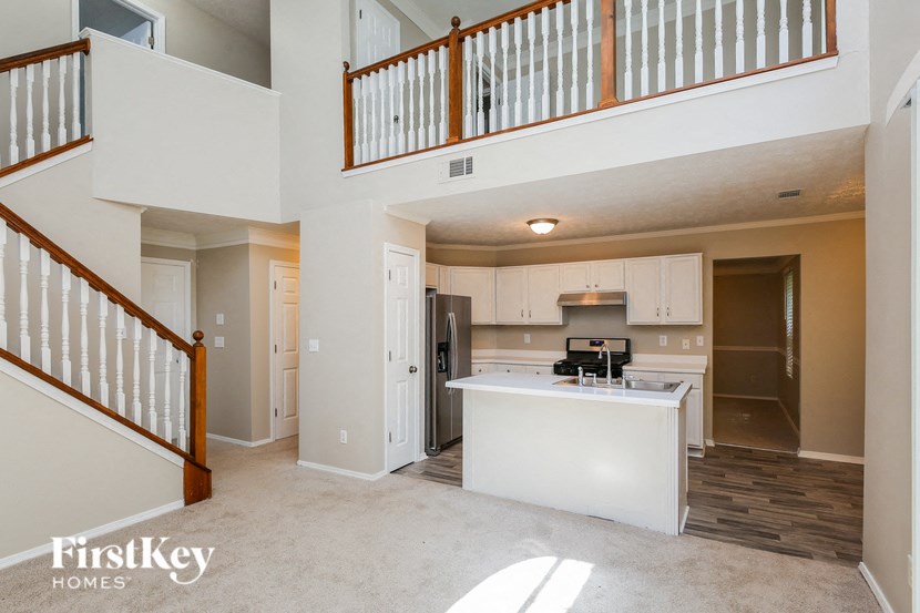 an open kitchen and living room with a staircase