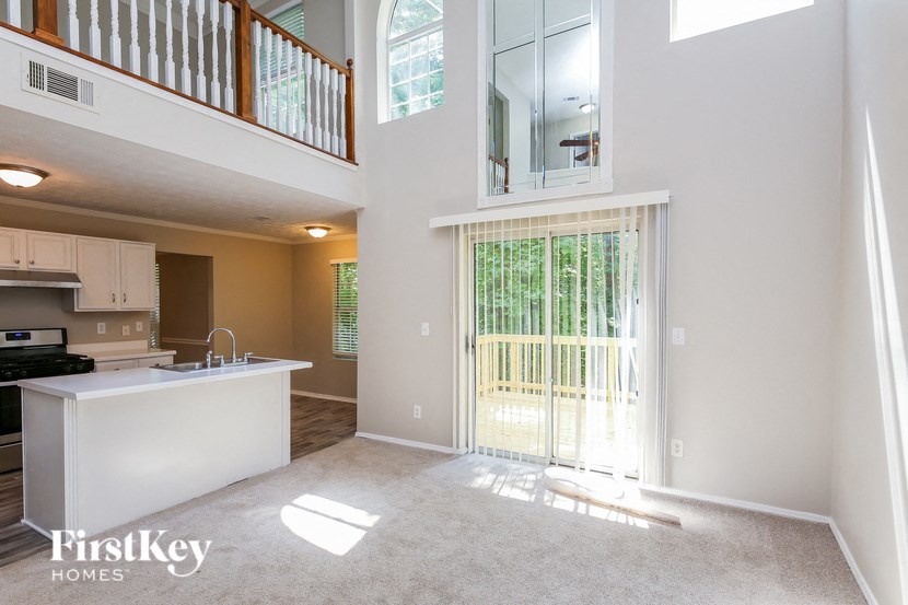 an open kitchen and living room with a door to a balcony