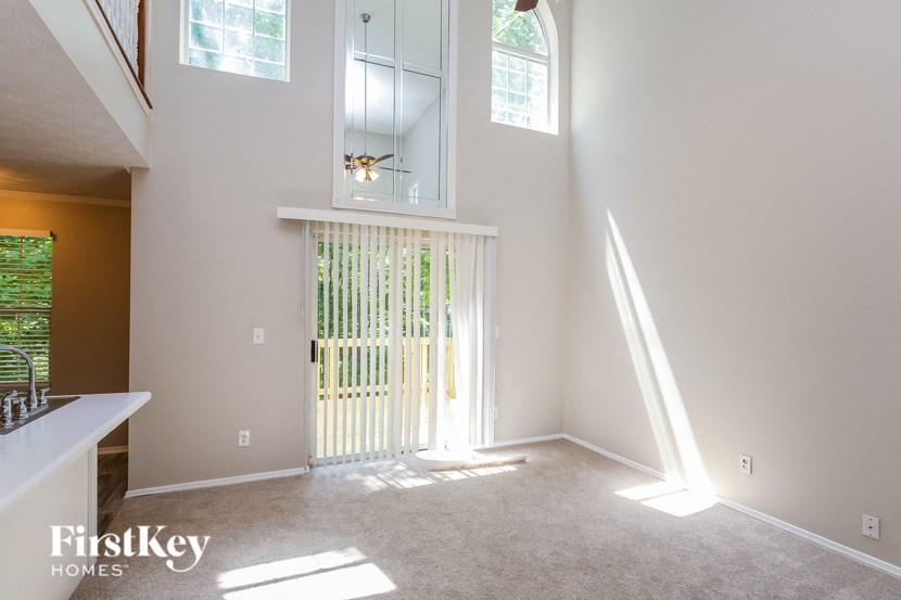 an empty living room with a white door and window