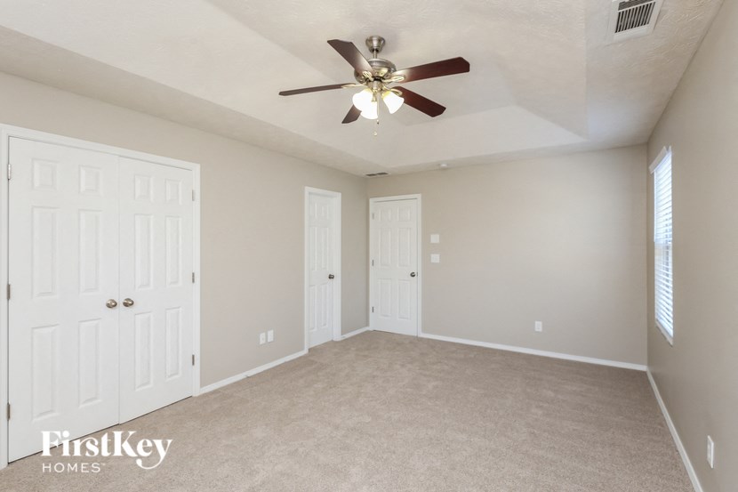 a bedroom with two closets and a ceiling fan