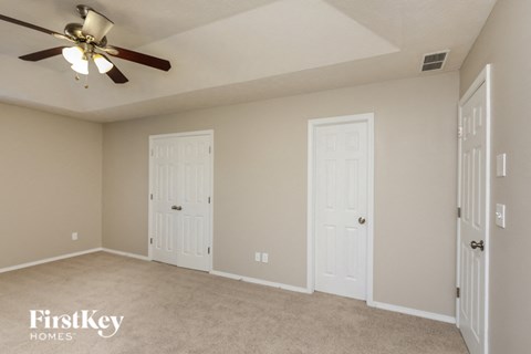 a living room with two doors and a ceiling fan