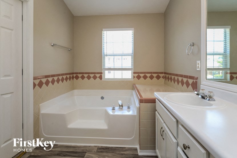 a bathroom with a tub and a sink and a mirror