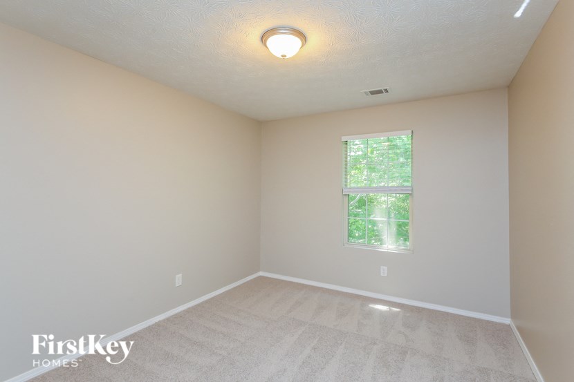 an empty room with a window and white walls