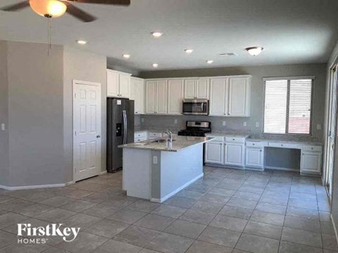 A kitchen with white cabinets and a tile floor.