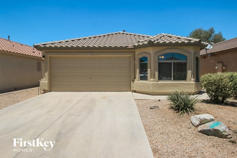 A house with a garage and a driveway in front of it.