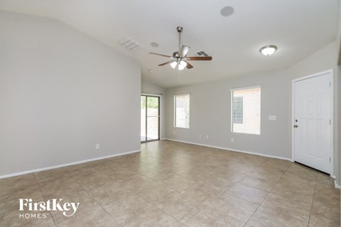 A spacious room with a ceiling fan and tiled flooring.