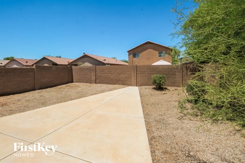 A brown house with a concrete walkway in front of it.