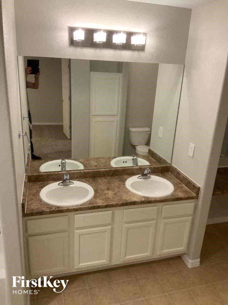 a bathroom with two sinks and a large mirror