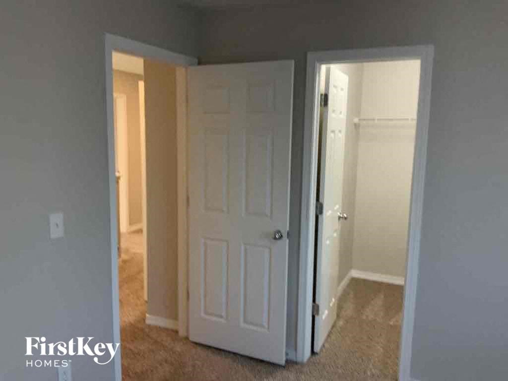 a bedroom with a white door and a closet