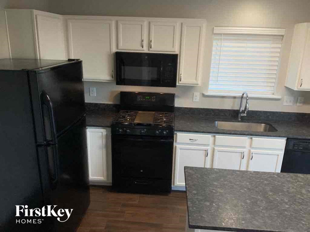 a kitchen with black appliances and white cabinets