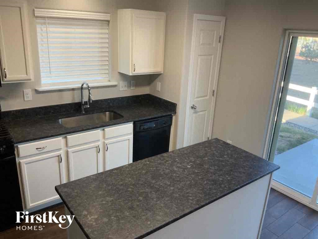 a kitchen with white cabinets and a counter top and a sink