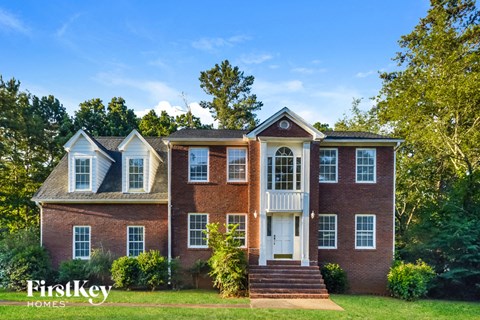 a red brick house with white windows and a white front door