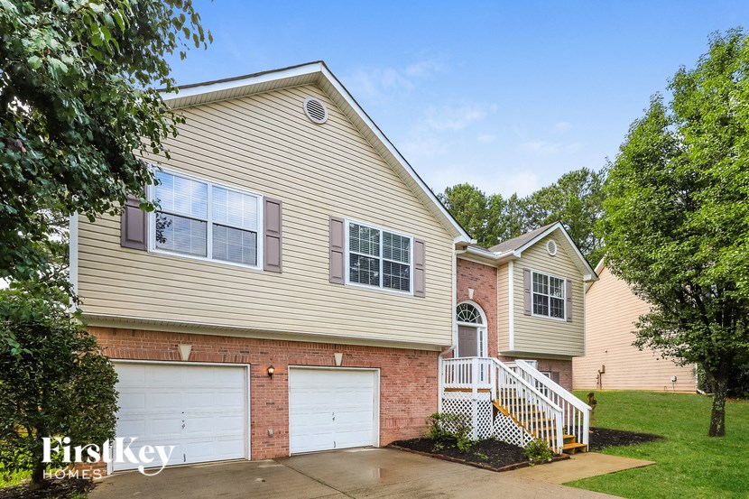 a beige house with two white garage doors