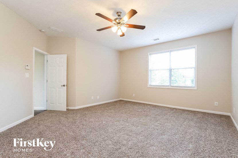 an empty room with a ceiling fan and a window