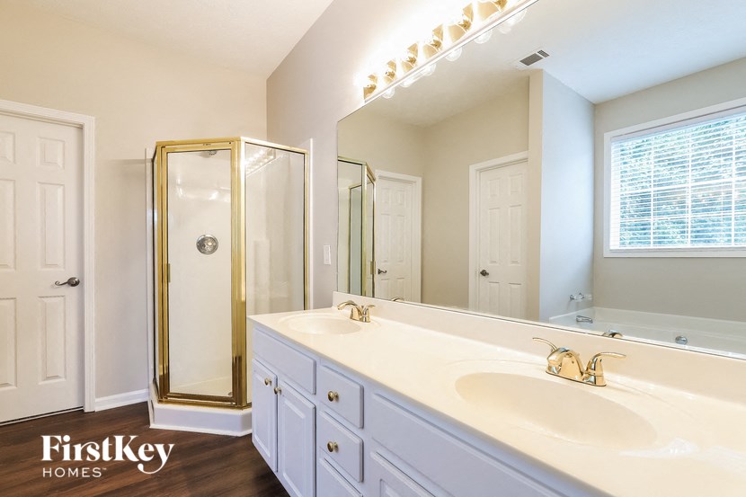 a white bathroom with two sinks and a shower