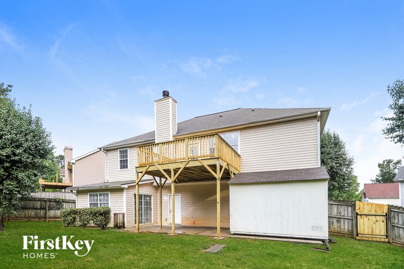 the back of a house with a deck and a yard