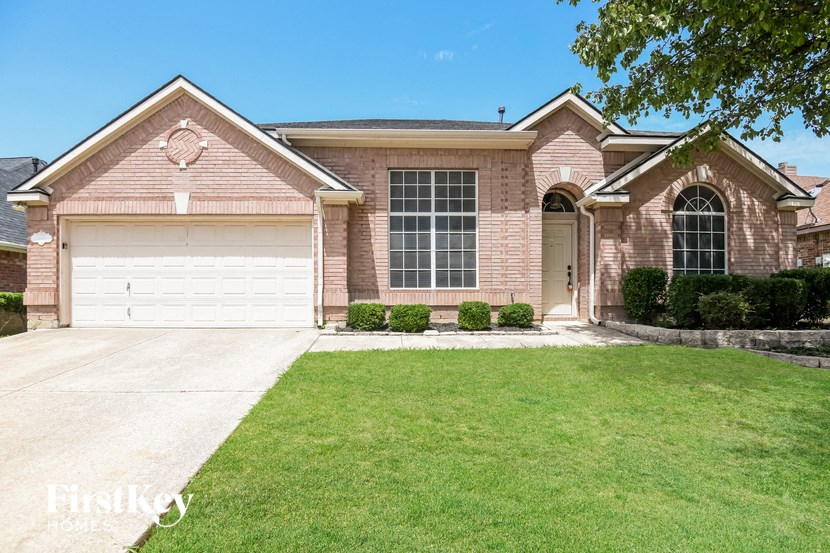 a brick house with a white garage door and a lawn