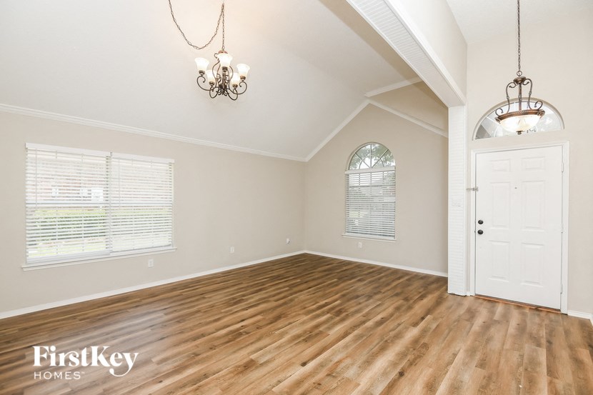 an empty living room with wood floors and a white door