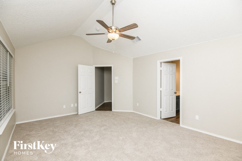 an empty living room with a ceiling fan