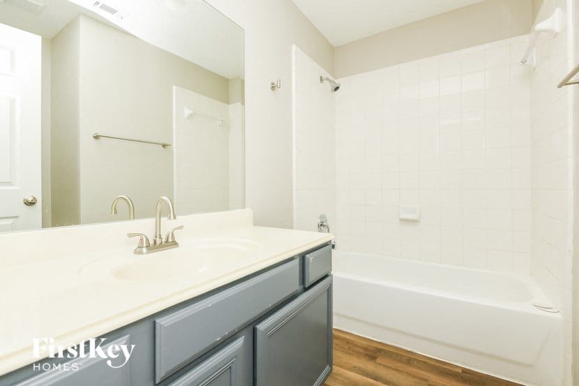 a bathroom with a sink and a tub and a mirror