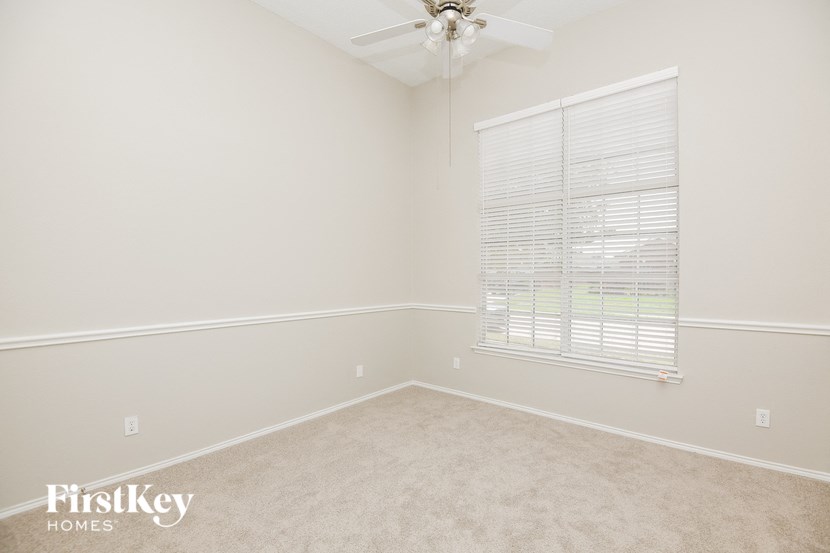 a bedroom with a ceiling fan and a window