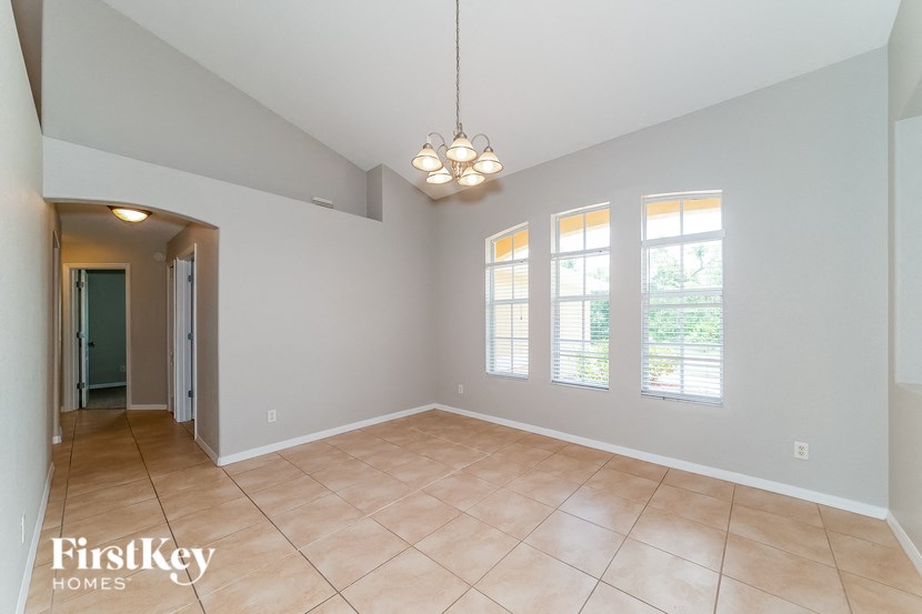 an empty living room with windows and a door to a hallway