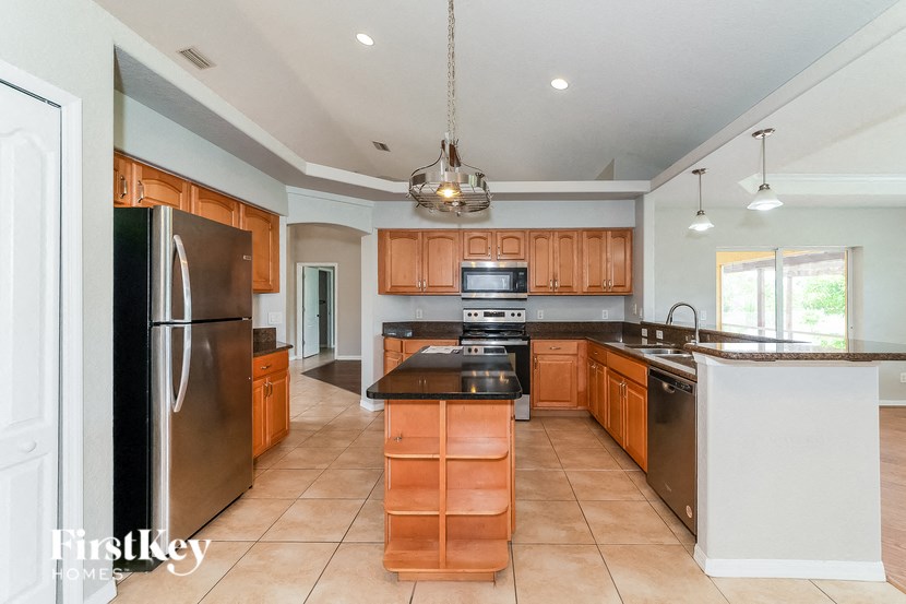 a large kitchen with wooden cabinets and stainless steel appliances