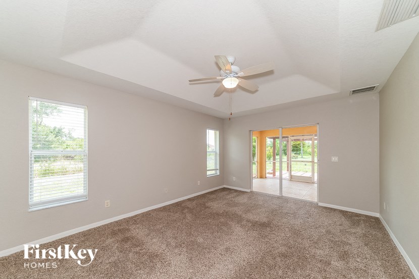 an empty living room with a ceiling fan and a window