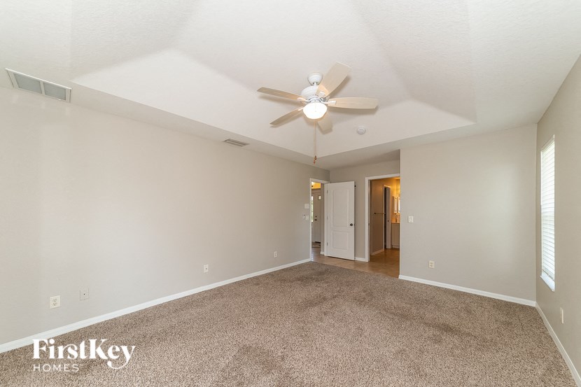 an empty living room with a ceiling fan