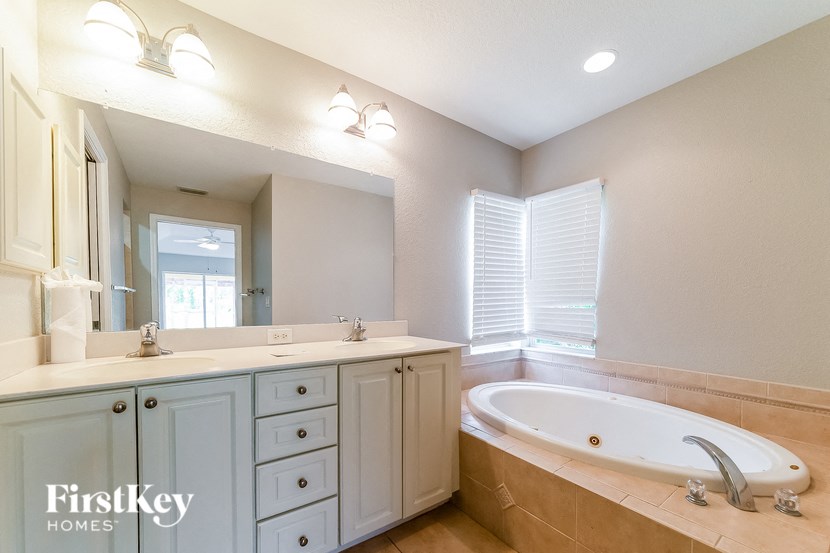 a bathroom with a tub and a sink and a mirror