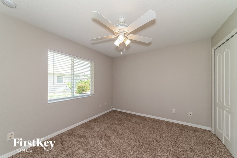 a bedroom with a ceiling fan and a window