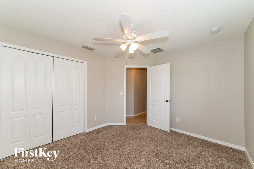a bedroom with two closets and a ceiling fan
