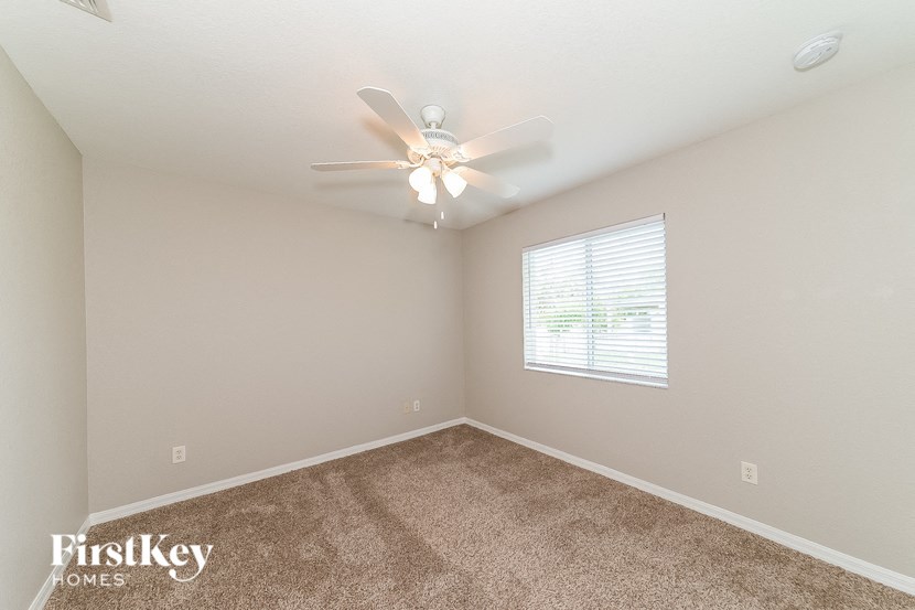 a bedroom with a ceiling fan and a window