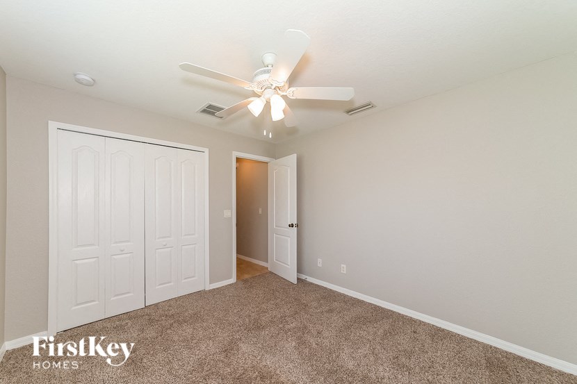 a bedroom with a ceiling fan and a closet